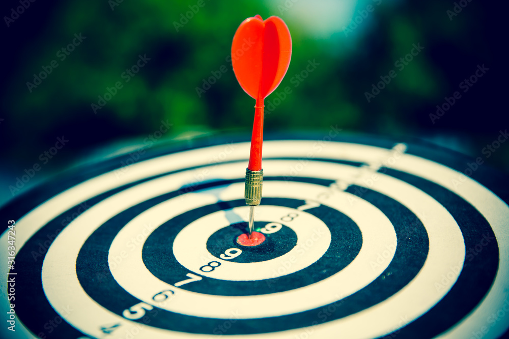 Close up red color arrow in the center of Bullseye or bull's-eye Visually suggesting an archery target, and hitting the bullseye is a term for an unexpectedly good success. Close up red color arrow in the center of Bullseye or bull's-eye Visually suggesting an archery target, and hitting the bullseye is a term for an unexpectedly good success.