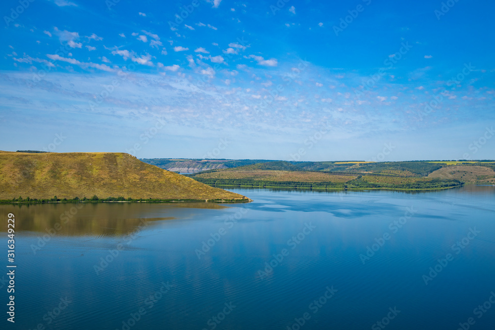 peaceful lake water hill land picturesque spring time scenery landscape nature reserve horizon view empty blue sky background copy space for your text here