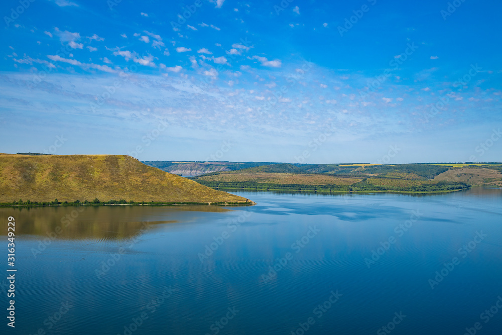 Fototapeta premium peaceful lake water hill land picturesque spring time scenery landscape nature reserve horizon view empty blue sky background copy space for your text here