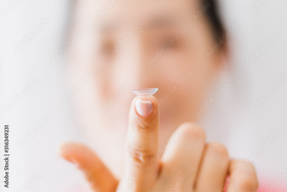 Naklejka premium Beautiful Woman Putting Eye Lenses With Hands