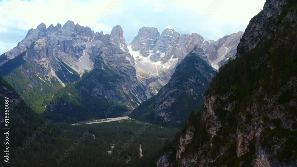 Dramatic scenery of high glorious mountain range on clear summer day. Spectacular Alps mountain peaks covered by pine forest woods. Drone flight. Dramatic scenery of high glorious mountain range on clear summer day. Spectacular Alps mountain peaks covered by pine forest woods. Drone flight.