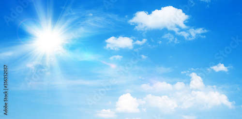Sunny natural background  blue sky with sun and white clouds.