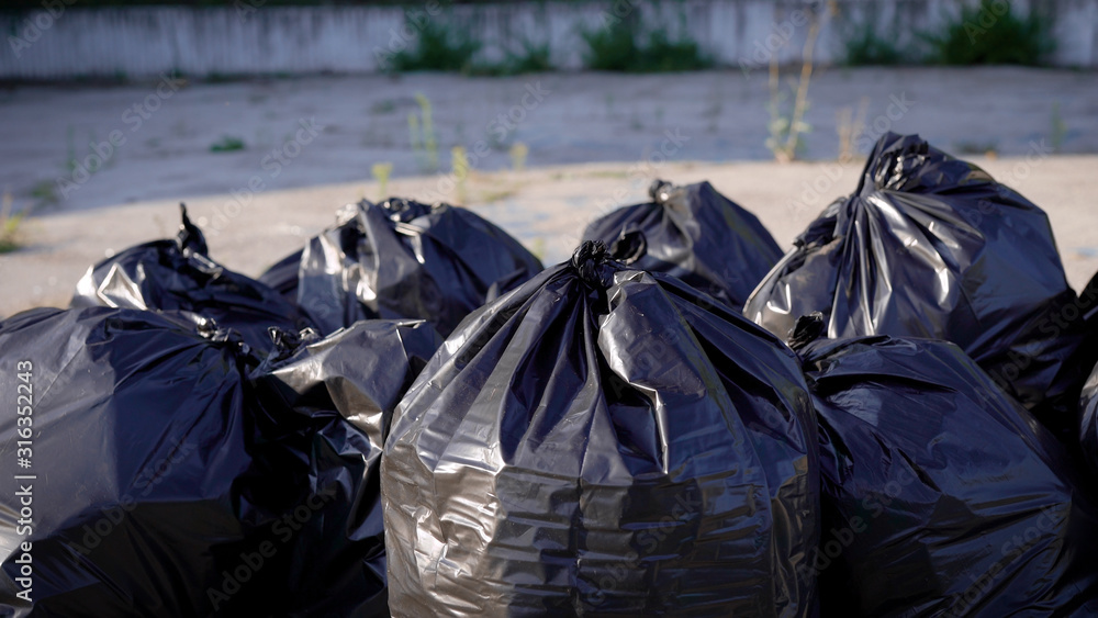 Black garbage bags are made up in place. A garbage truck will arrive soon and take out the garbage. Black garbage bags are made up in place. A garbage truck will arrive soon and take out the garbage.