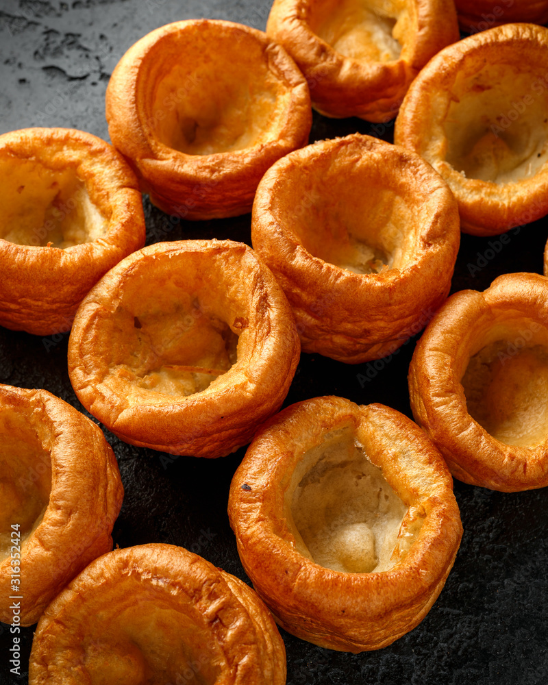 Traditional English Yorkshire pudding side dish on black rustic background Traditional English Yorkshire pudding side dish on black rustic background