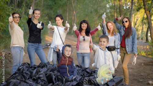 A group of young women and children gathered a lot of garbage bags in nature. Volunteers are happy with the result  the park was cleaned of pollution  an environmental campaign was held.