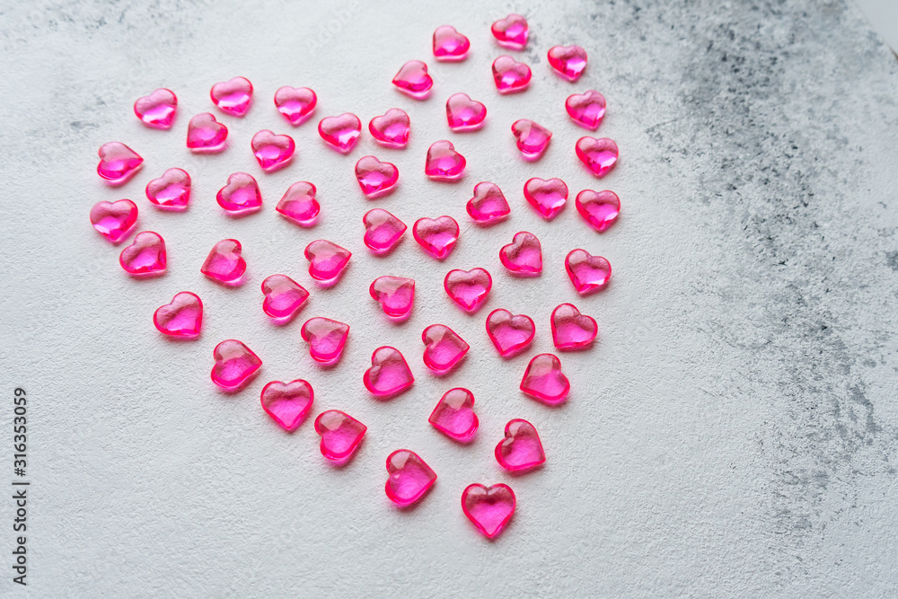 Heart made of pink plastic hearts on a white background Heart made of pink plastic hearts on a white background