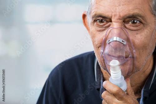 Portrait of a senior man wearing an oxygen mask. (Health and Fitness) 