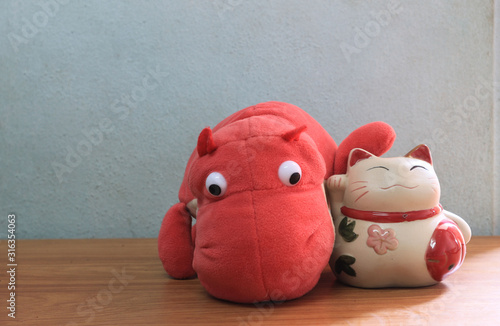 Japanese lucky cat doll with a pink hippo doll