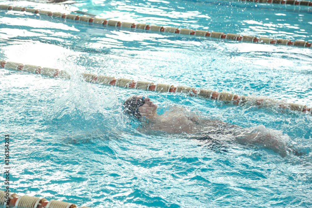 A teenager is swimming in a sports pool