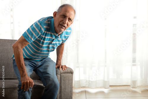 фотографія Senior man trying to stand up with a knee pain