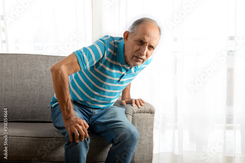 Принти на полотні Senior man trying to stand up with a knee pain