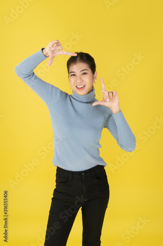 Women with thumbs pointing on both sides in the yellow background.