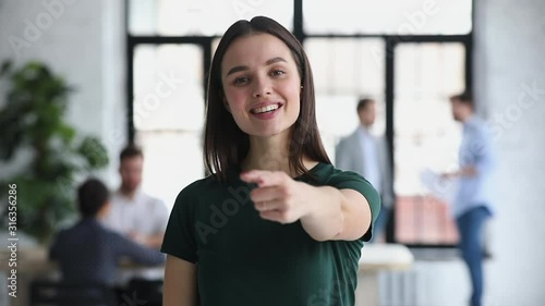 Confident young businesswoman looking pointing finger at camera choosing you photo