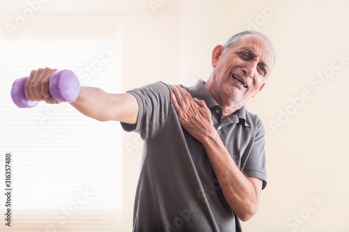 Senior man doing exercises with weights. (Health and fitness)
