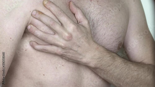 caucasian man without shirt with hand on chest , neutral color profile