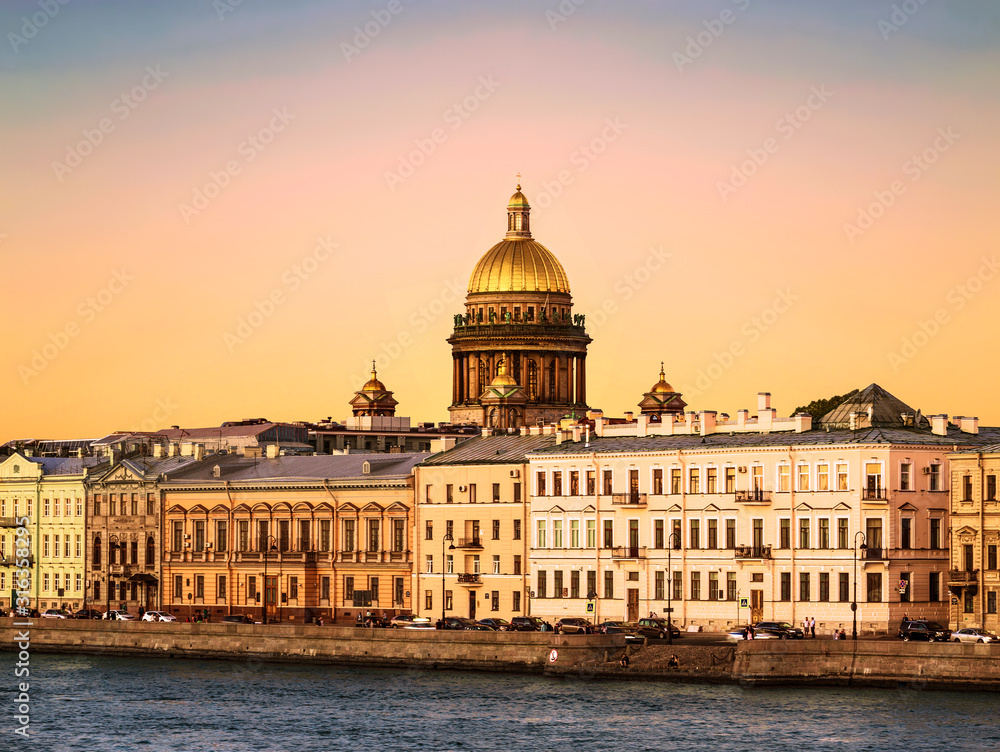 View of the English embankment of the Neva river and the dome of St. Isaac's Cathedral at sunset. Saint Petersburg, Russia