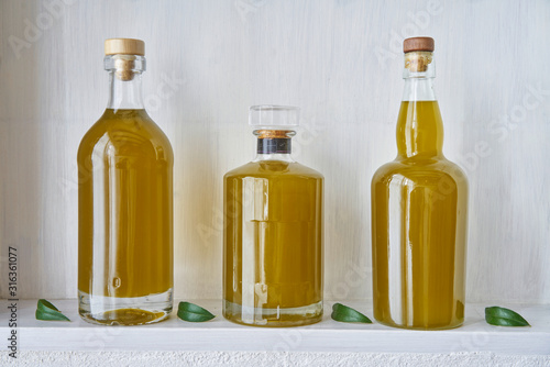 detail olive oil bottle bottles oils three living gold food cooking natural organic beauty country house healthy stylish white leef green kitchen shelf closeup