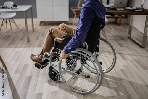 Businessman Sitting On Wheelchair In Office