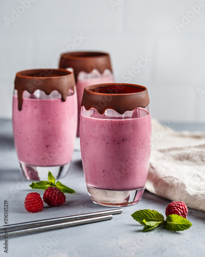 Raspberry banana smoothie in glasses covered with chocolate