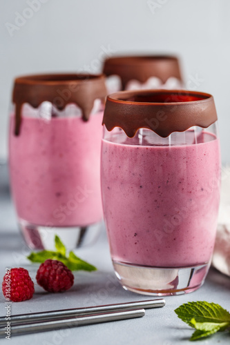 Raspberry banana smoothie in glasses covered with chocolate
