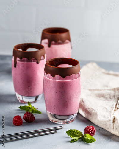 Raspberry banana smoothie in glasses covered with chocolate