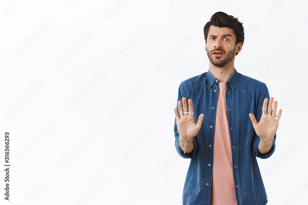 Worried guy doesnt like how offer sounds, trying avoid bad affairs, shaking hands in no reply, rejecting or refusing something suspicious and awful, cringe from aversion or dislike, white background - obrazy, fototapety, plakaty 