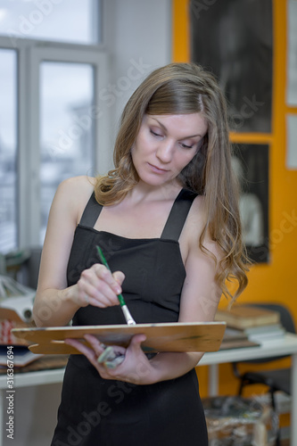 Artist woman paints in art studio