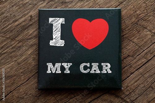 I Love My Car written on black note with wood background