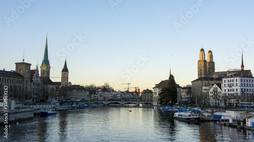 timelapse sunset over zurich city bellevue switzerland with river limmat. downtown zurich orange sunset over grossmünster and frauenkirche photo