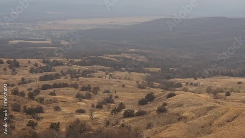 Mountain valleys with yellow autumn grass overgrown with rare trees. Russia, Caucasus, Psebay photo