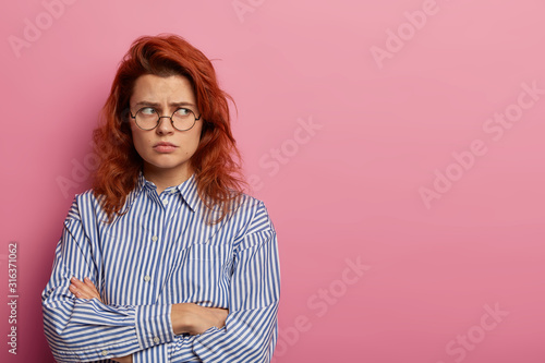 Canvas Print Photo of offended displeased angry woman stands with insulted look and crossed h