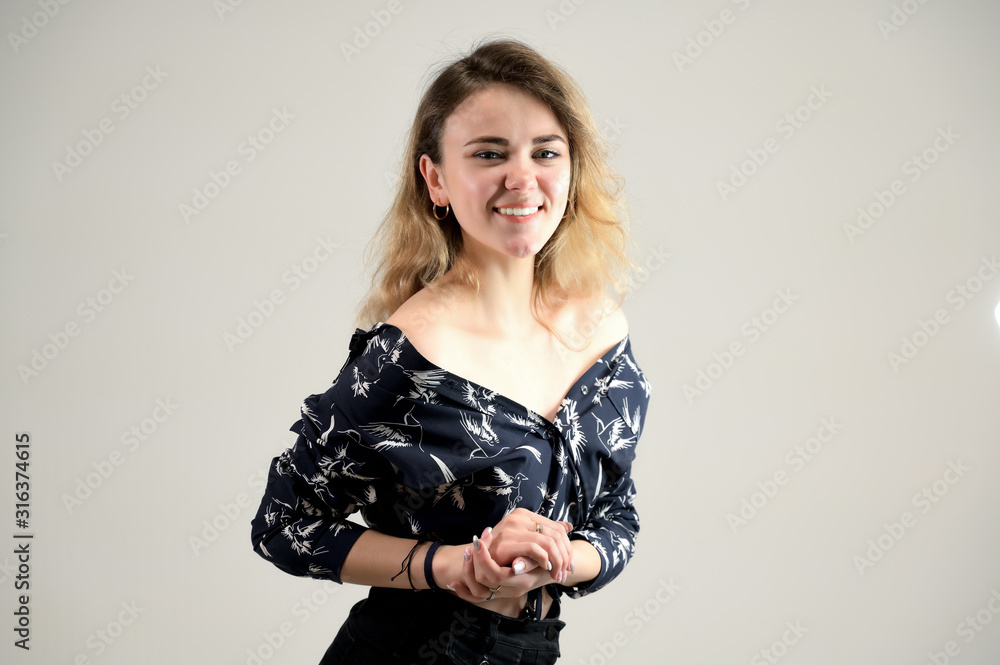 Concept woman in a dark shirt smiles and talks. Photo Portrait of a girl model with excellent makeup with good teeth in the studio on a white background. Concept woman in a dark shirt smiles and talks. Photo Portrait of a girl model with excellent makeup with good teeth in the studio on a white background.