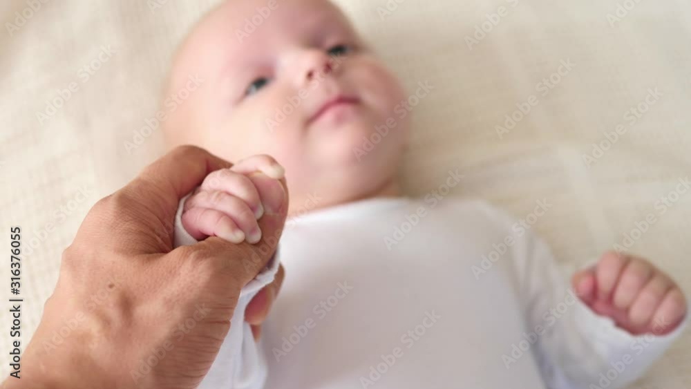 Father Hand Holding Tiny Baby Hand. Close-Up. Father Hand Holding Tiny Baby Hand. Close-Up.