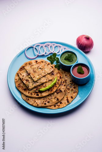 Onion Parotha / Pyaj parantha / kanda paratha served with tomato ketchup and green chutney. selective focus