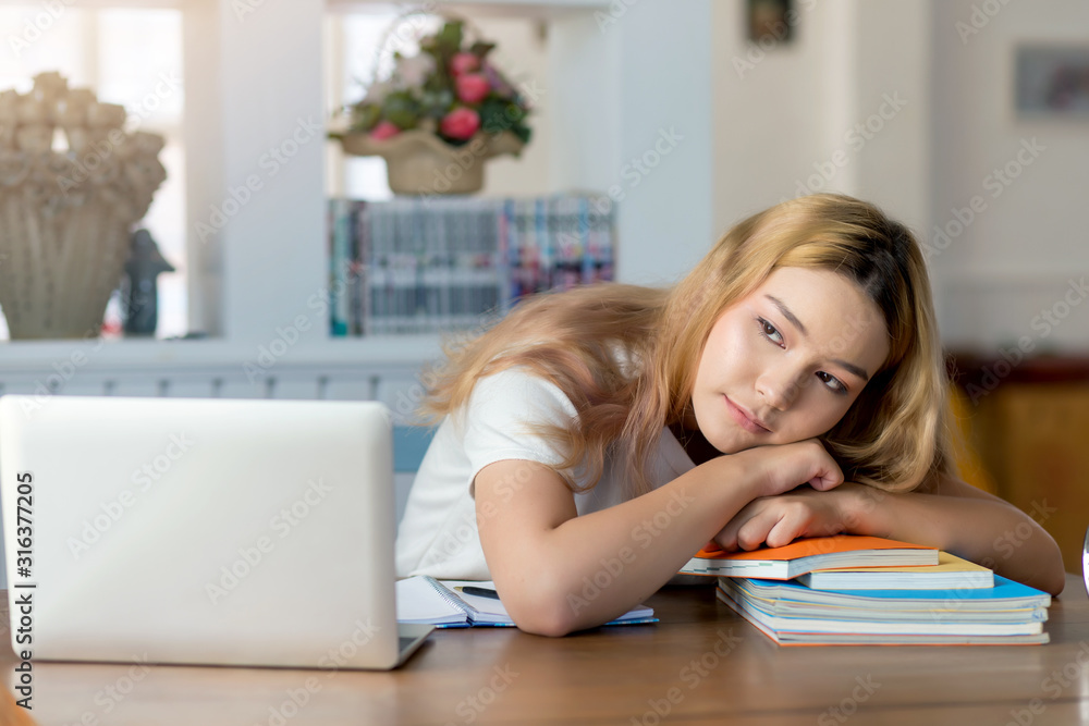 Young asian woman student sitting thinking at library with laptop and books on the table. Young asian woman student sitting thinking at library with laptop and books on the table.