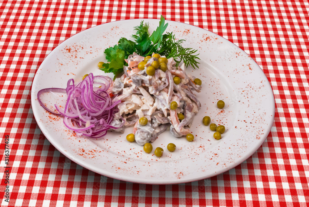 Traditional Russian salad Olivier decorated with onion and green vegetables Traditional Russian salad Olivier decorated with onion and green vegetables