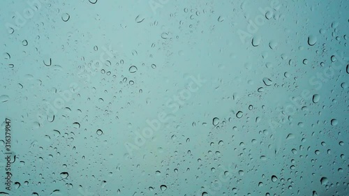 Fresh water drops after raining on blue glass window background in car.