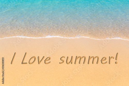 I love summer written in a sandy tropical beach.
