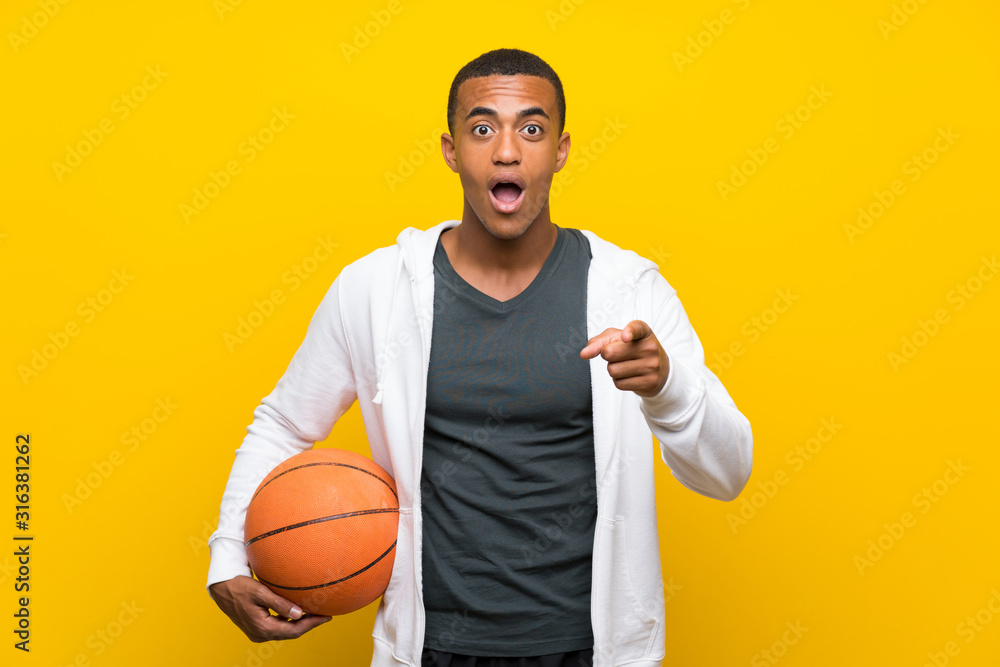 African American basketball player man surprised and pointing front