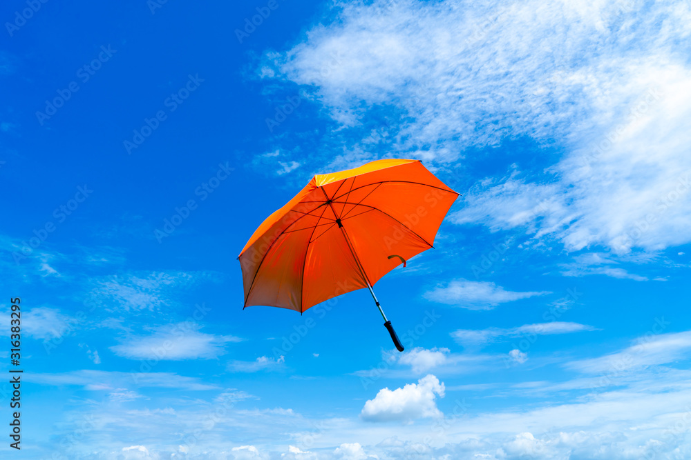 Multicolored of rainbow umbrella in bottom view for protect skin from the sun, high uv on the blue summer sky with white fluffy clound. Freedom in the blue sky.