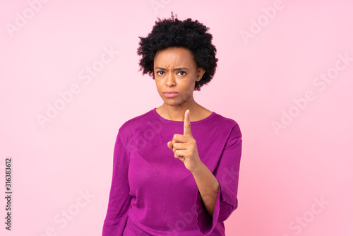 African american woman over isolated pink background frustrated and pointing to the front