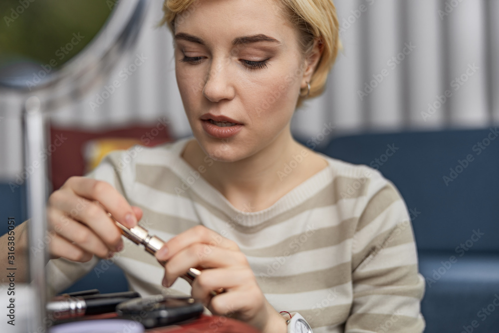 Pretty female blogger showing makeup on camera Pretty female blogger showing makeup on camera