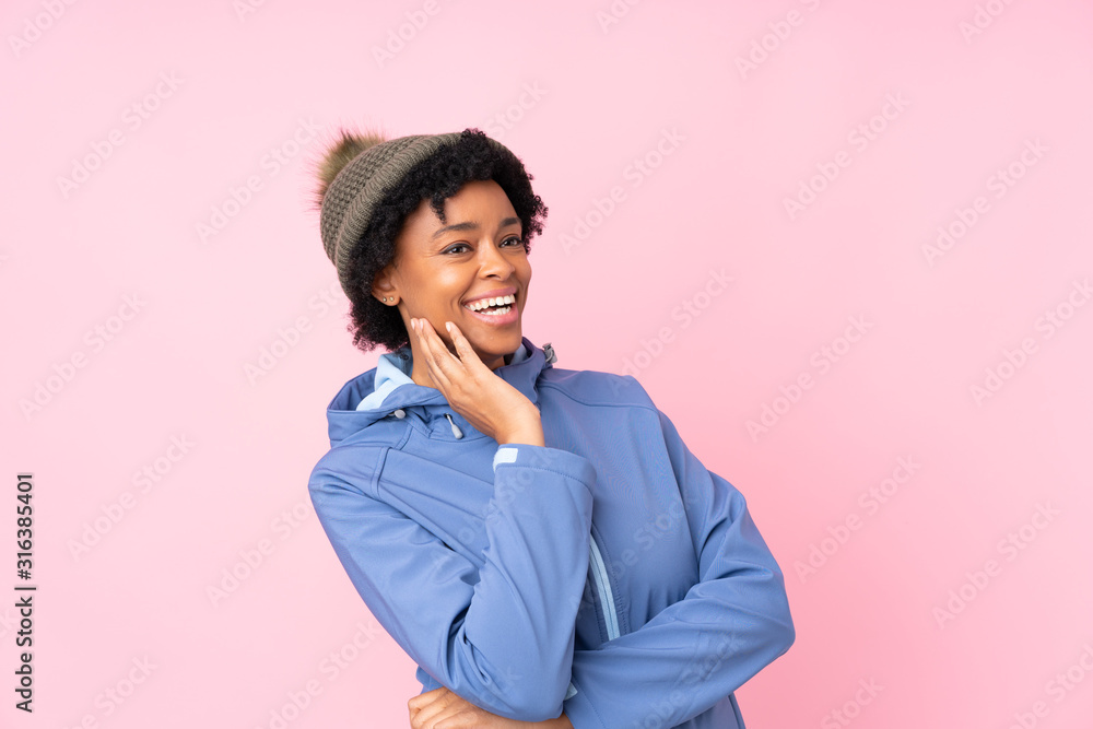 African american woman with winter hat over isolated pink background laughing African american woman with winter hat over isolated pink background laughing