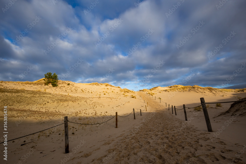 Dunes in the Slowinski National Park. Landscape with beautiful sky, clouds and dunes in the sun. Czolpino, Leba, Poland.