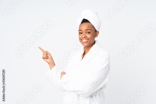 African american woman  in a bathrobe over isolated background pointing finger to the side