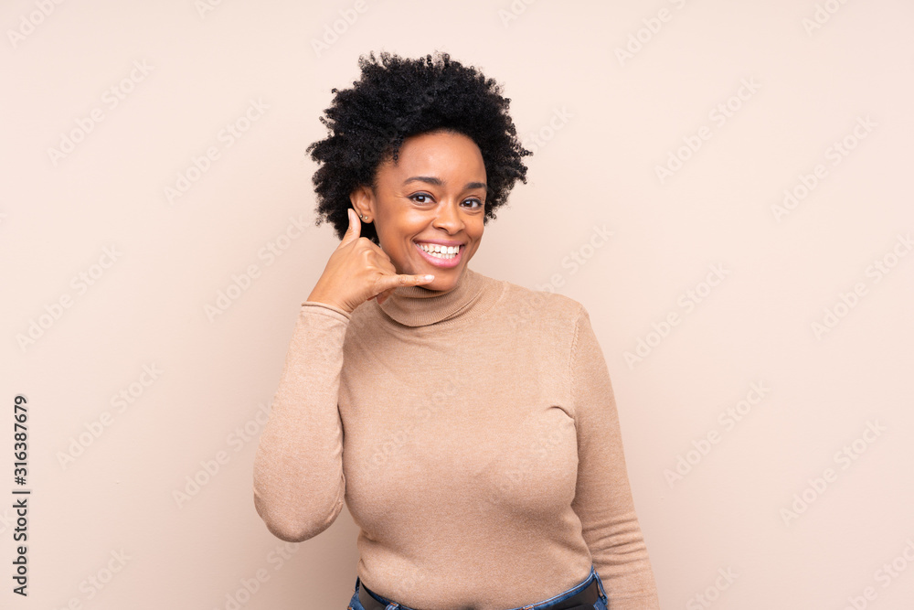 African american woman over isolated background making phone gesture. Call me back sign African american woman over isolated background making phone gesture. Call me back sign