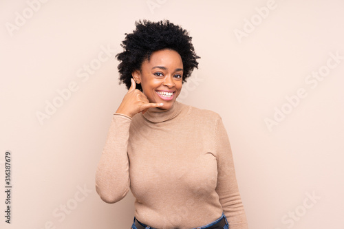 African american woman over isolated background making phone gesture. Call me back sign