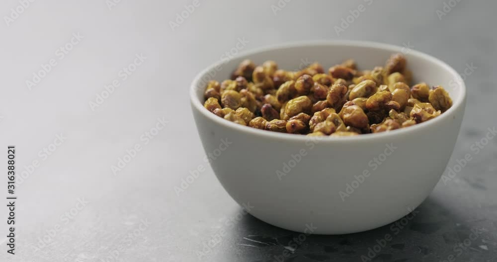 Slow motion handheld shot of dried seaberry in white bowl on terrazzo countertop Slow motion handheld shot of dried seaberry in white bowl on terrazzo countertop