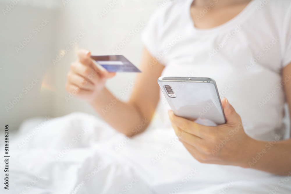 Technology, Online shopping, Digital banking, home lifestyle concept, a beautiful Smiling Asian woman with smart phone and credit card at home for business payment, career, e-commerce trading Technology, Online shopping, Digital banking, home lifestyle concept, a beautiful Smiling Asian woman with smart phone and credit card at home for business payment, career, e-commerce trading