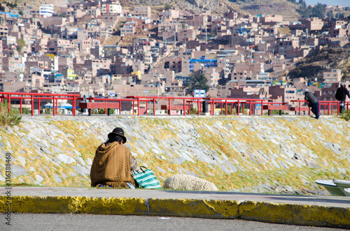 Man with Lama is sitting at the harbour of Puno, Peru.